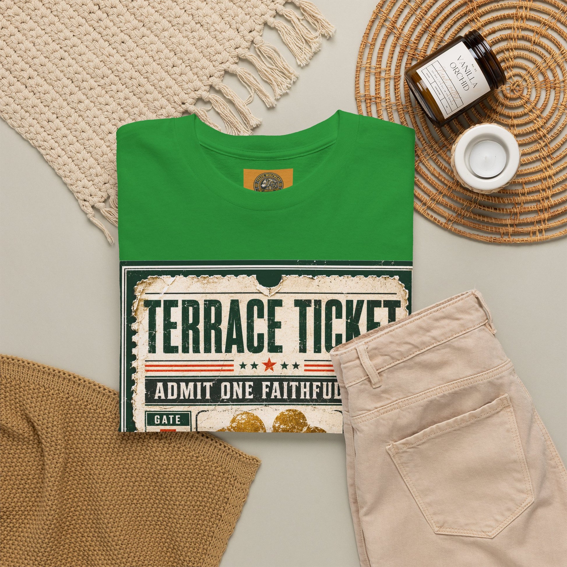 Forest green T-shirt flat lay with ticket graphic and gold four-leaf clover