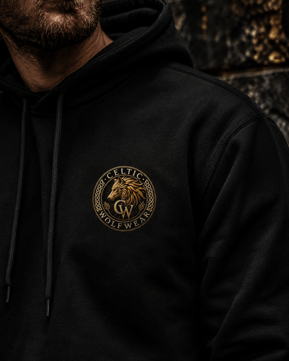 Close-up of the gold Celtic Wolfwear wolf logo printed on a black hoodie