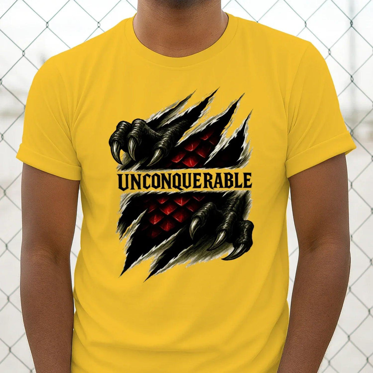 Yellow short-sleeve t-shirt with centered black dragon claw graphic and UNCONQUERABLE print