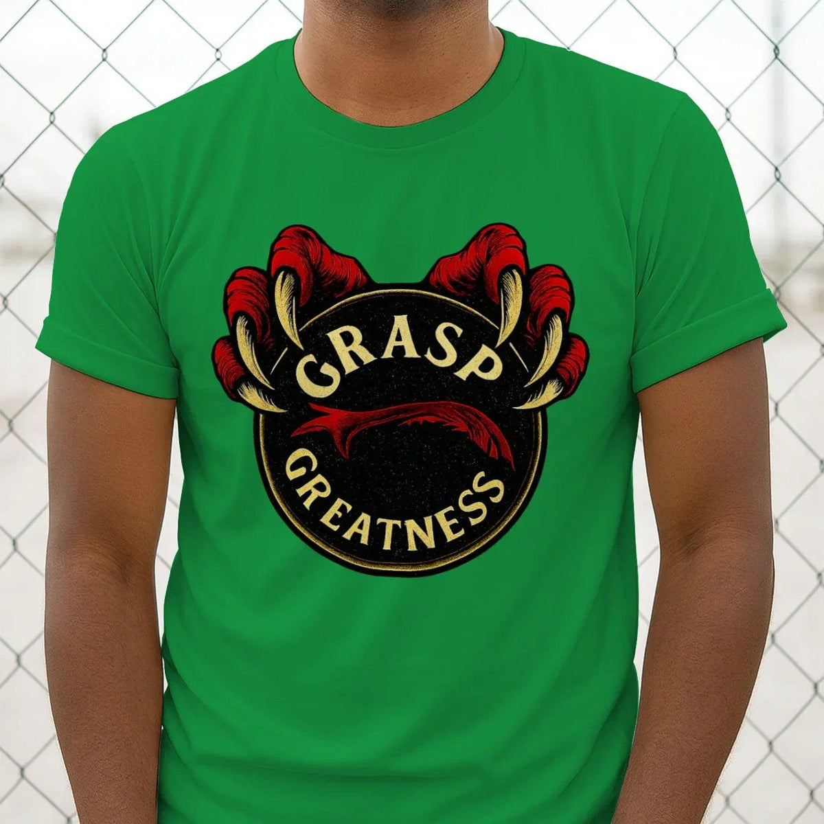 Green t-shirt close-up: GRASP GREATNESS crest graphic